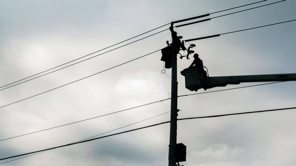 An electric utility worker in Easton, Pennsylvania in 2017. Such traditional networks may one day be replaced by high-tech microgrids. (uAmerican Public Power Association/Unsplash/u)