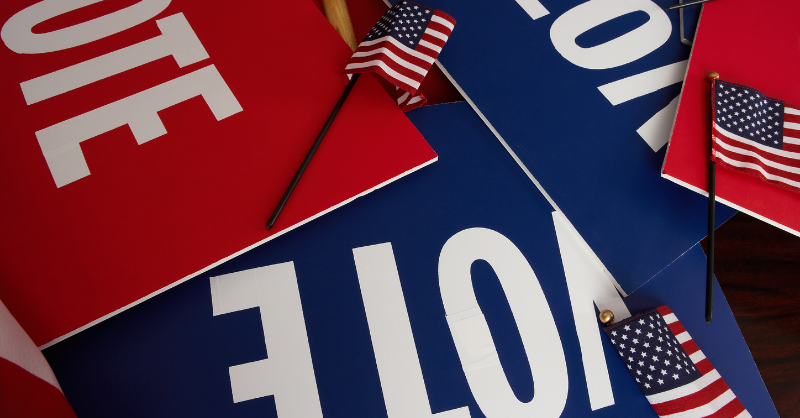 Stock photo of “VOTE” placards and small American flags. (Ballotpedia)