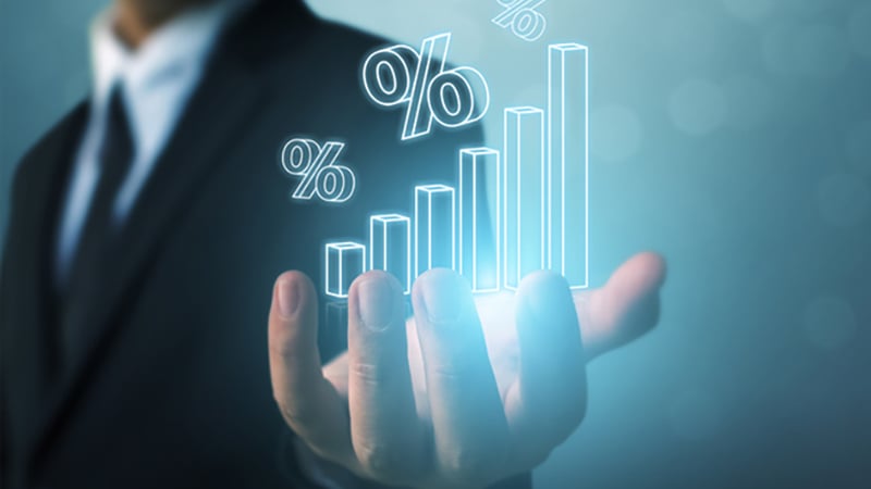 A business professional presenting a glowing holographic bar chart, symbolizing growth and protection through commercial insurance.