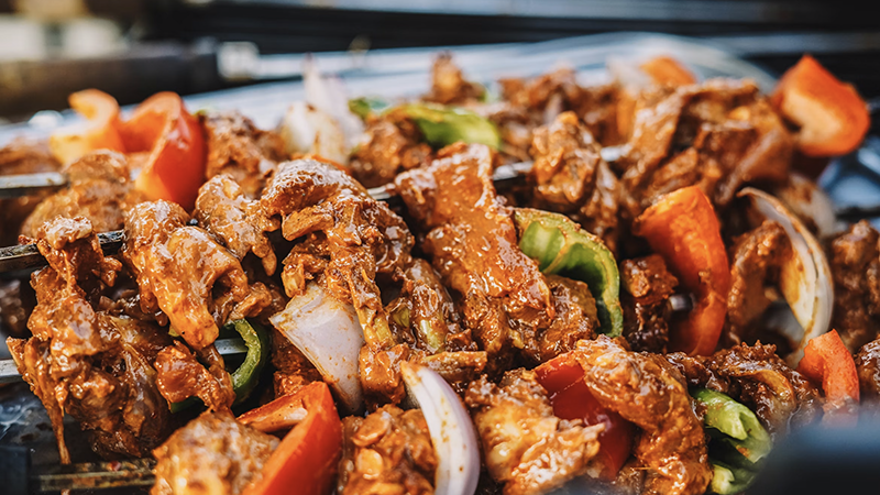 A close-up of skewers with marinated meat and vegetables, showcasing vibrant colors and glossy textures, perfect for holiday grilling inspiration.