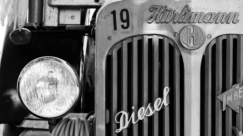 A close-up of a vintage diesel truck's front grille and headlight, showcasing its classic design and robust build.