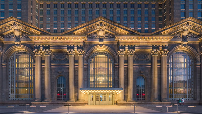 Illuminated facade of Michigan Central Station at night, showcasing its historic architecture and grand reopening after 112 years.