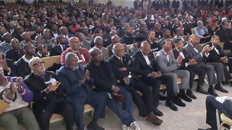 A large gathering of men at a community event, showcasing unity and engagement.
