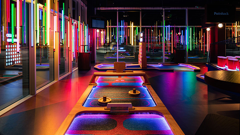 Vibrant mini-golf course at Puttshack, showcasing colorful LED lights and modern entertainment in St. Louis.