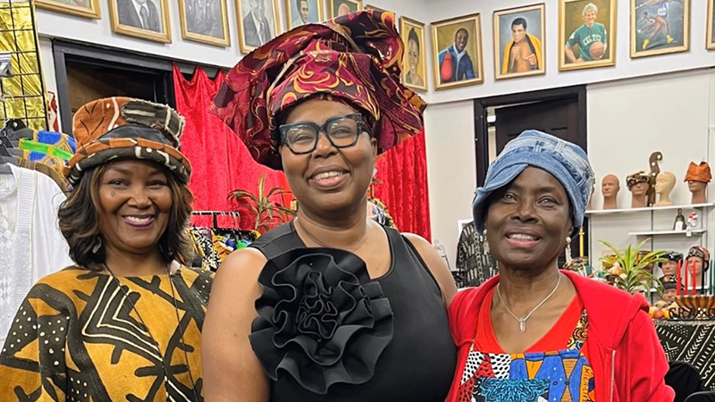 Three women celebrating Black History Month in vibrant African-inspired attire.
