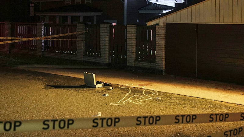 Crime scene in St. Louis with chalk outline and evidence markers at night.