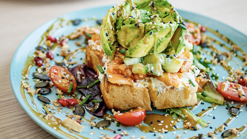 Healthy avocado toast with everything bagel seasoning on a ceramic plate.