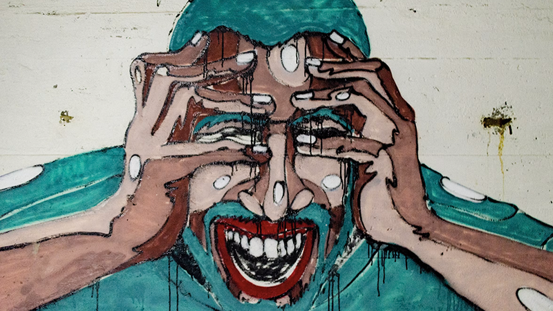Person showing the adverse impact of stress on health, head in hands under pressure