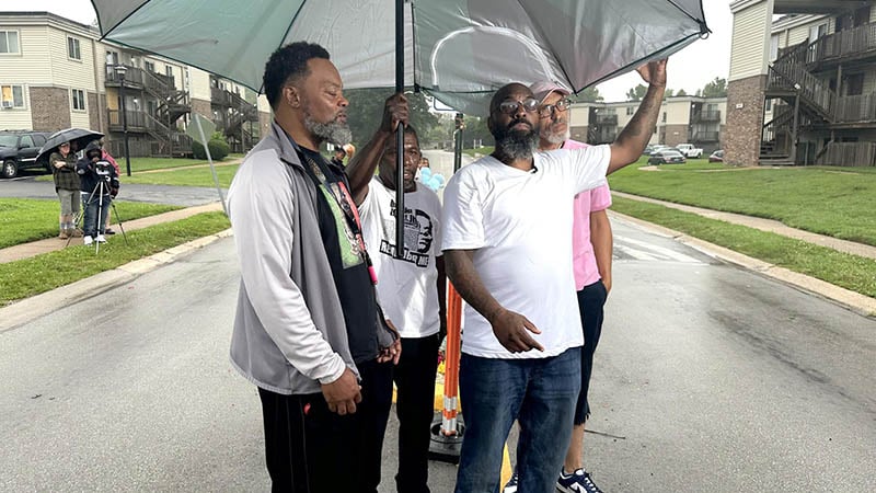 Alt Text: Michael Brown Sr. addressing volunteers and supporters during the memorial rebuild event in Ferguson.