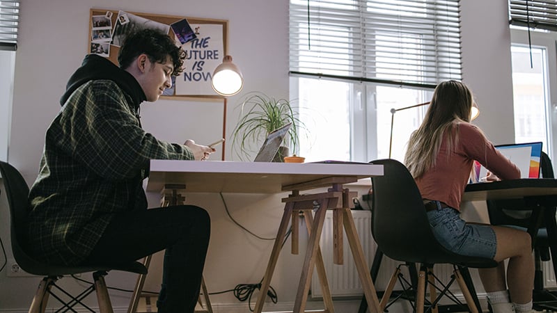 Young professionals exploring coolest jobs outperforming corporate careers at a modern collaborative desk setup.