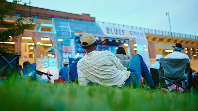 Live musical performers on stage with the Gateway Arch framed in the background during the Blues at the Arch Festival.