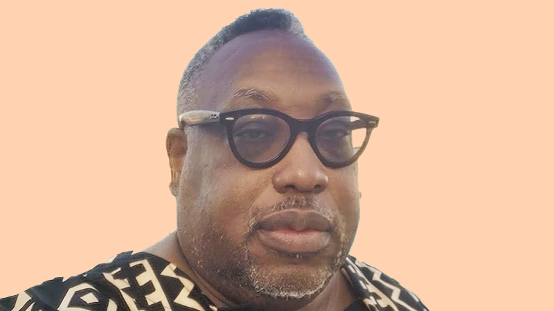 Portrait of David Beckford, founder of Dynasty Media, wearing glasses and a patterned shirt, against a light background.