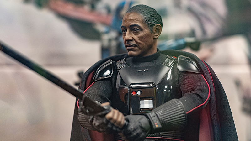 Collectible figure of Moff Gideon from The Mandalorian, holding the Darksaber, showcased at a pop-culture fan event.