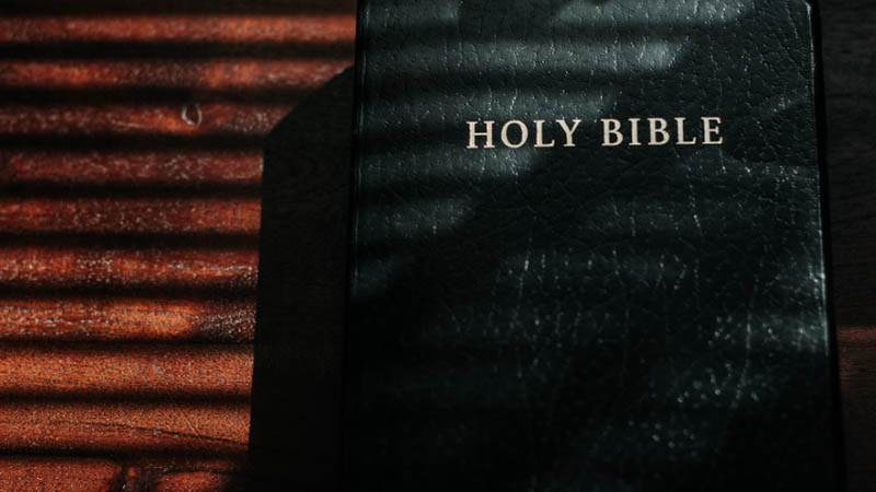  A Holy Bible resting on a wooden surface, symbolizing the intersection of faith and financial discussions in Black churches.
