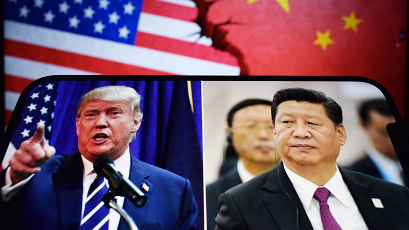 Smartphone screen showing Donald Trump and Xi Jinping with American and Chinese flags in the background.
