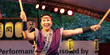 Performers playing traditional Japanese taiko drums outdoors on stage at Missouri Botanical Garden during Labor Day weekend.