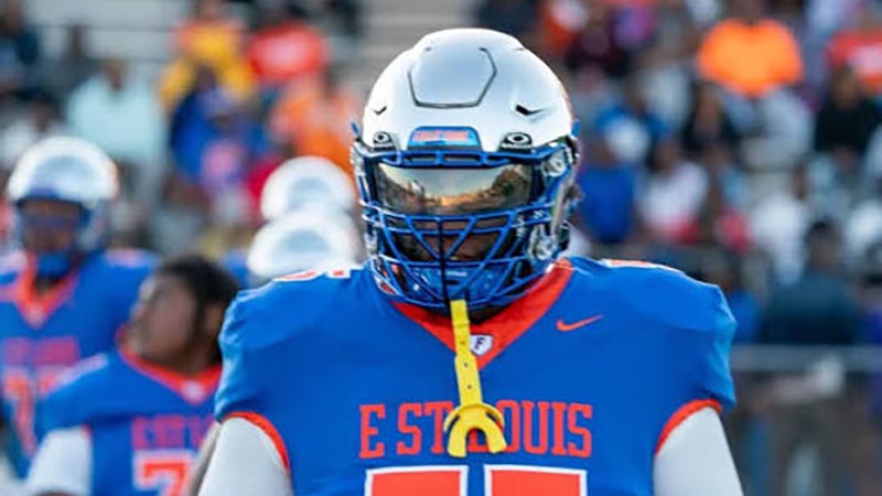 East St. Louis Flyers high school football player in blue and orange jersey wearing a silver helmet with tinted visor for Metro East community safety and growth sports coverage.