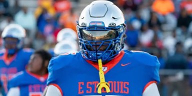 East St. Louis Flyers high school football player in blue and orange jersey wearing a silver helmet with tinted visor for Metro East community safety and growth sports coverage.