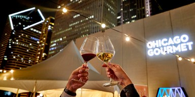 Outdoor tasting tents and dining tables set up against the Chicago skyline in Millennium Park.