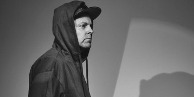 Producer and turntablist DJ Shadow performing behind mixing equipment and turntables