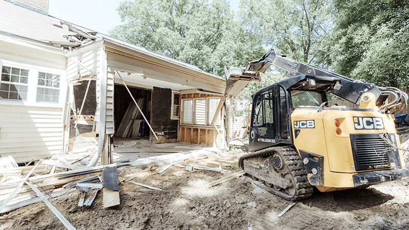 Heavy demolition equipment tearing down an abandoned residential home as part of Metro East Illinois news initiatives.