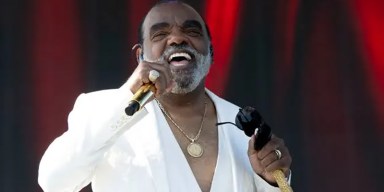 Legendary soul musician Ronald Isley smiling during a live performance appearance