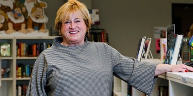 Missouri policy roundup report on DESE leader Karla Eslinger smiling inside a school library surrounded by bookshelves.