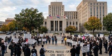 Civil rights demonstrators marching and holding protest signs during a rally for justice in Missouri.