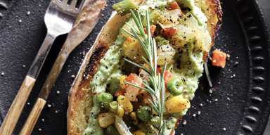 Slices of thick toasted sourdough topped with mashed avocado, cherry tomatoes, and microgreens