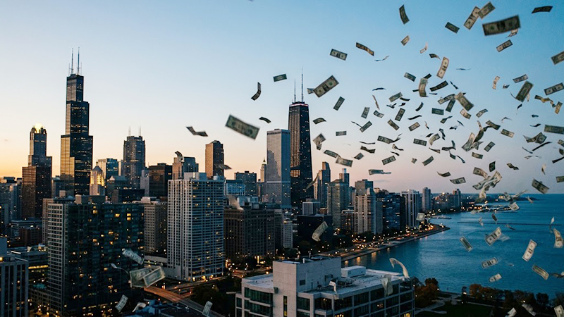 Chicago budget deficits illustrated by hundred dollar bills blowing across the Chicago skyline at dusk.