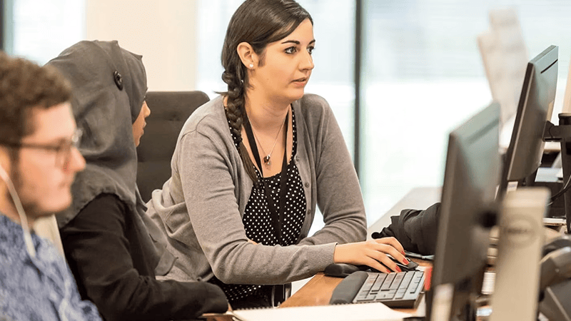 An entrepreneur reviewing marketing plans with a business advisor across a conference table.