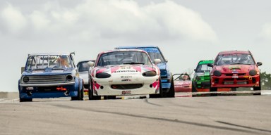 Historic vintage sports cars racing down the track at Ozarks International Raceway in Gravois Mills, Missouri.