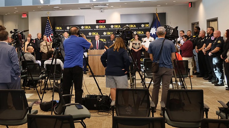 Minnesota law enforcement officials speaking at a podium during a joint agency press conference