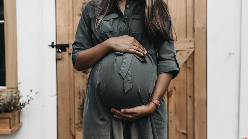 Chicago healthcare and labor actions impact as pregnant woman holds belly outside